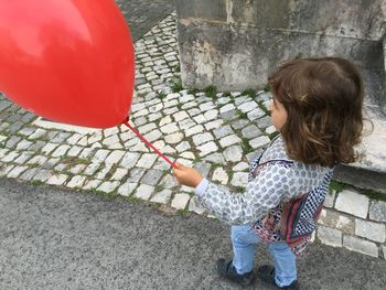 High angle view of girl with balloon standing outdoors