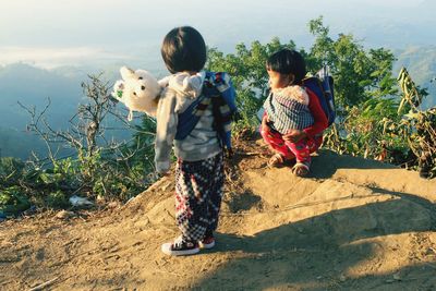 Sisters with toys on cliff