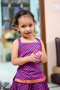Portrait of cute smiling girl standing indoors