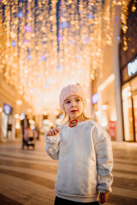 Portrait of young woman standing on street