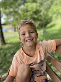 Portrait of smiling boy sitting outdoors