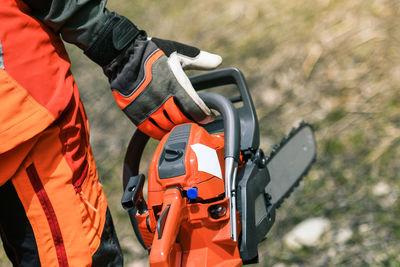 Man holding chainsaw and cut tree. lumberjack at work wears protective equipment. gardener working 