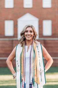 Portrait of a smiling young woman standing against building