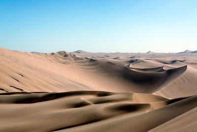 Scenic view of desert against clear blue sky at huacachina