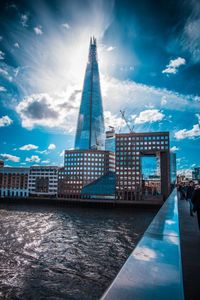 Buildings in city against cloudy sky