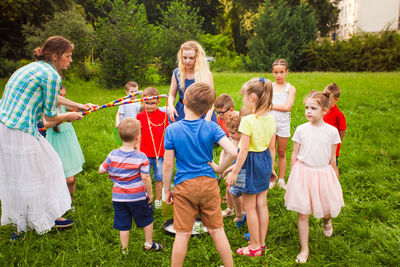 Women playing with children at park