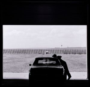 Man leaning on car in garage