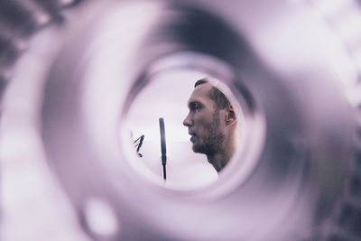 Side view of mid adult man looking away seen through hole