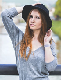 Portrait of young woman holding hat