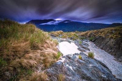 Scenic view of mountains against cloudy sky