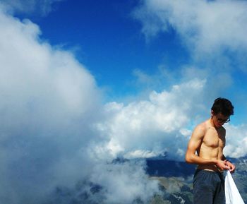 Young man standing against sky