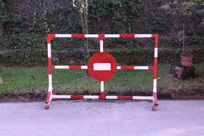 Red wooden fence against plants