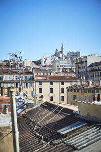 Buildings in city against clear blue sky