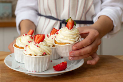 Midsection of man holding ice cream in plate on table