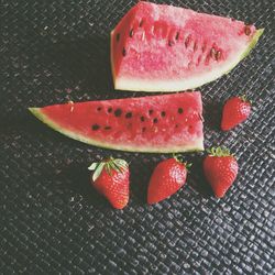 Watermelon slices and strawberries on table