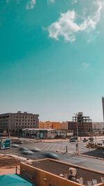 Road by buildings in city against sky