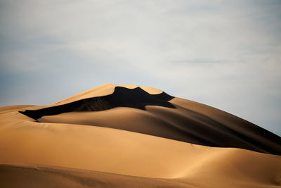 Low angle view of sand dune in desert against sky