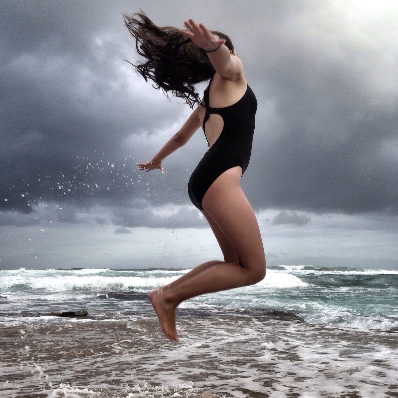 sea, water, sky, horizon over water, beach, mid-air, lifestyles, leisure activity, full length, wave, cloud - sky, jumping, motion, freedom, arms outstretched, vacations, vitality, shore