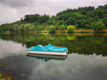 Boat moored in lake against sky