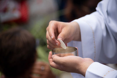 Priest distributes the hostia during mass for santa luzia at the pilar church