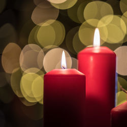 Close-up of illuminated candles against christmas lights