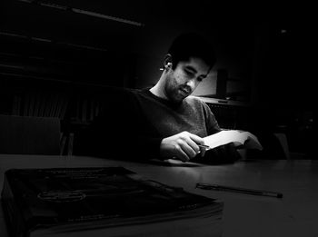 Portrait of man sitting on table at home