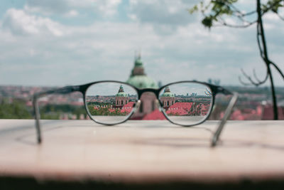 Close-up of eyeglasses on glass against sky