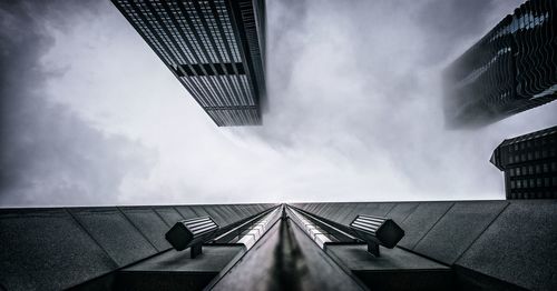 Modern office buildings against sky in foggy weather