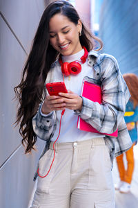 Portrait of smiling young woman using mobile phone