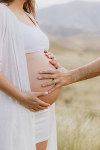 Midsection of couple holding hands