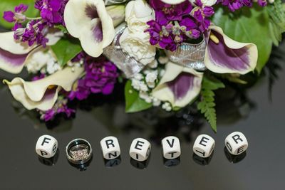 High angle view of dices with text by wedding bouquet on table