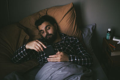 Young man sitting on sofa at home