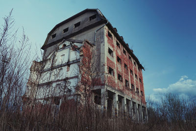 Low angle view of abandoned building against sky