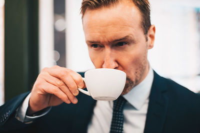 Mature businessman drinking coffee in cafe