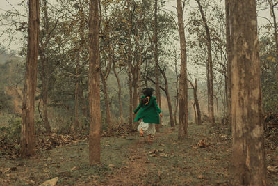 Rear view of woman walking in forest