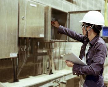 Manual worker wearing hardhat while working in factory