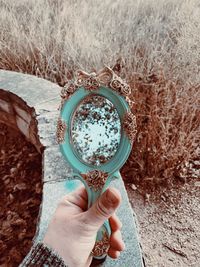 Midsection of person holding mirror