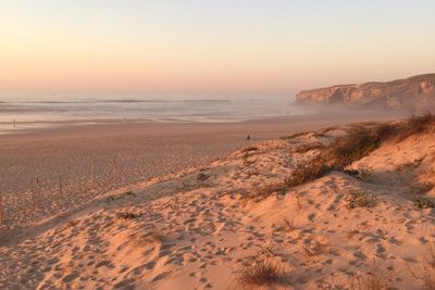 Scenic view of beach against sky during sunset