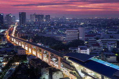 High angle view of illuminated city against sky during sunset