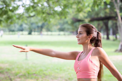 Young woman with arms outstretched standing outdoors
