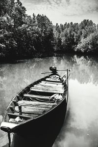 Boat moored on lake against sky