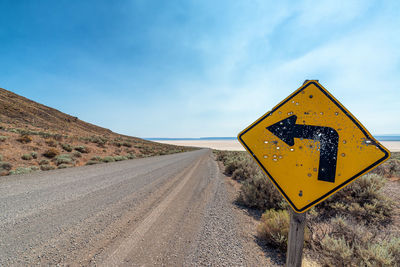 Road sign against sky