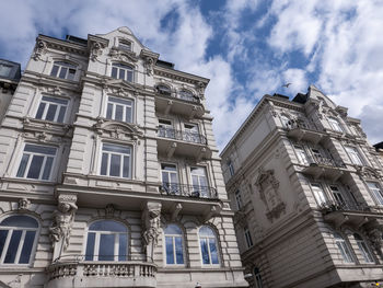 Low angle view of buildings against cloudy sky