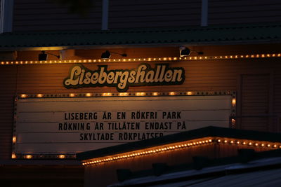 Low angle view of illuminated sign at night