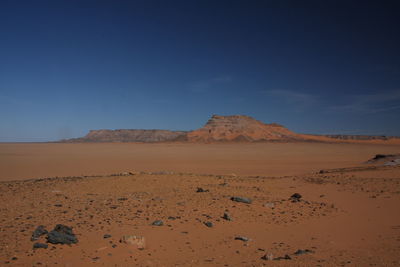 Scenic view of desert against blue sky