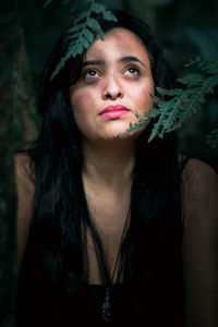 Close-up of thoughtful young woman in forest