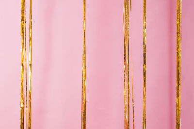 Golden curtain rain fringe on pink background. concept of valentine's day, birthday, mother's day