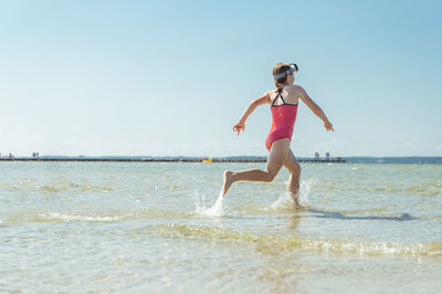 Full length of woman on beach against clear sky