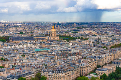 High angle view of city buildings against cloudy sky