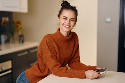 Portrait of young woman using mobile phone at home